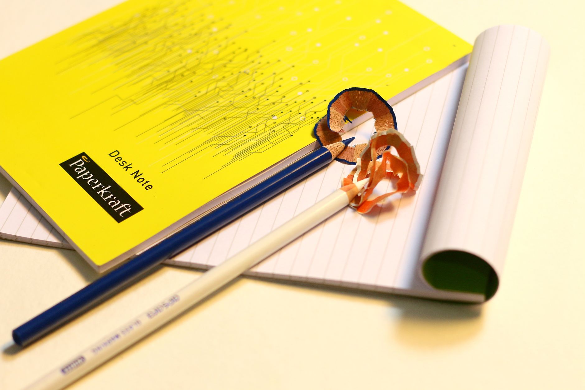 Vibrant stationery set featuring sharpened pencils and labeled notebooks on a desk, set up for planning a small client project.