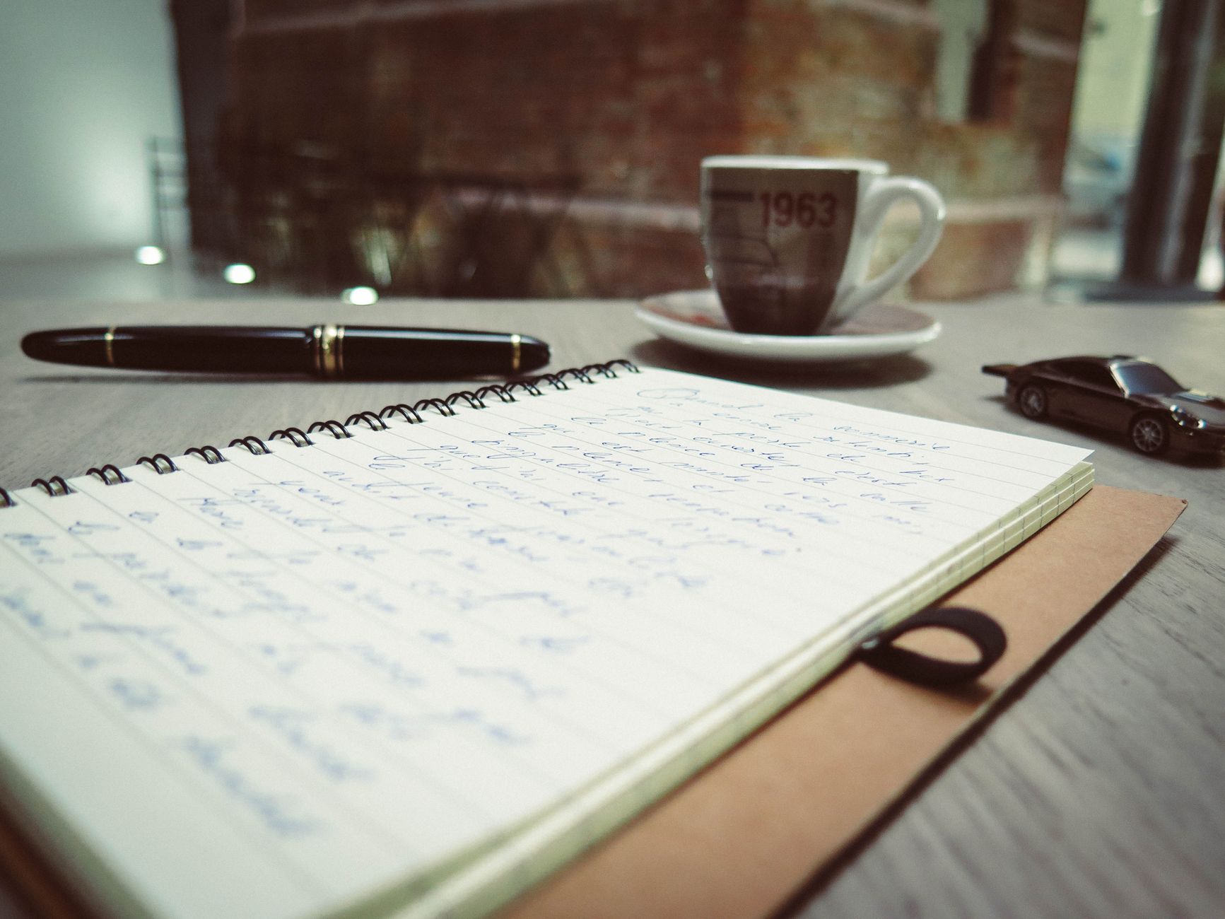 A warm, inviting workspace with coffee and handwritten notes, laid out for evening client work.