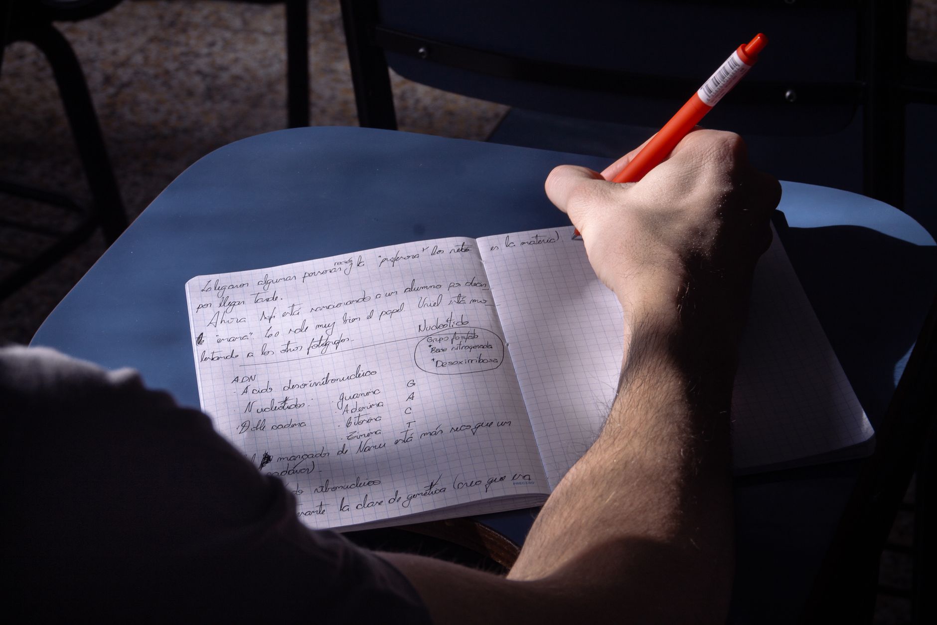A student takes notes in a classroom, working through a structured lesson step by step.